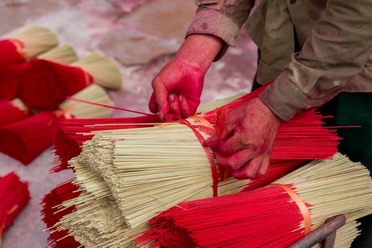 A person is cutting up red sticks with red and white sticks